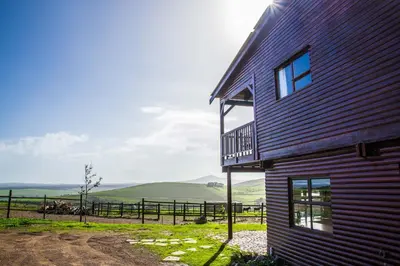 a building with a balcony on the side of it at Anna Beulah Farm in Durbanville