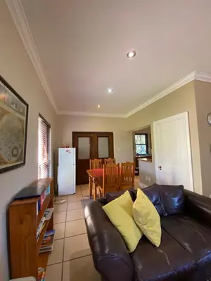a living room with a leather couch and a table at @Leisure Guest Suite in Stellenbosch