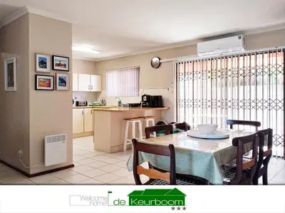 a kitchen and dining room with a table and chairs at De Keurboom Guesthouse in Kuilsrivier
