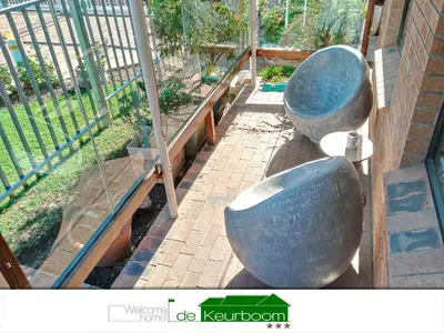 two large metal bowls sitting next to a fence at De Keurboom Guesthouse in Kuilsrivier