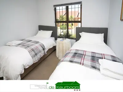 two beds sitting next to each other in a room at De Keurboom Guesthouse in Kuilsrivier