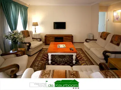 a living room with a couch and a coffee table at De Keurboom Guesthouse in Kuilsrivier