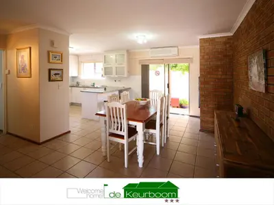 a kitchen and dining room with a table and chairs at De Keurboom Guesthouse in Kuilsrivier
