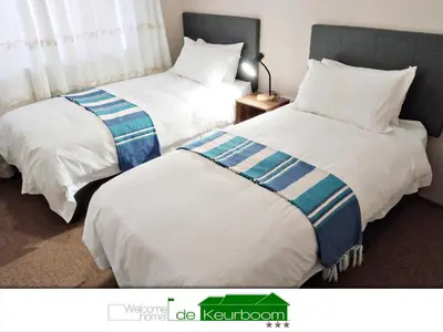 two beds sitting next to each other in a room at De Keurboom Guesthouse in Kuilsrivier