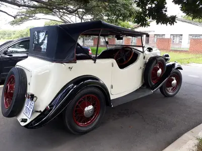 an old white car parked on the side of a street at Pelican Place Guest Cottages in Durbanville