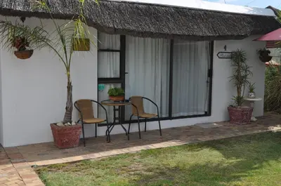 a patio with a table and chairs on a house at Pelican Place Guest Cottages in Durbanville