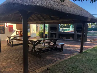 a picnic table and bench under a large umbrella at Amies Self-Catering Apartments in Panorama