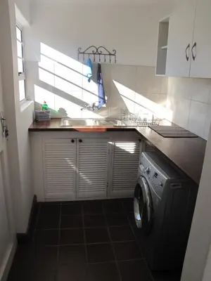 a kitchen with a sink and a washing machine at Induku in Stellenbosch