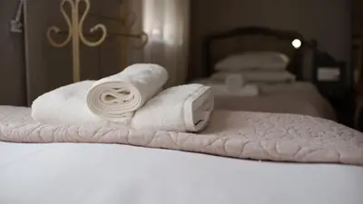 a pile of towels sitting on top of a bed at Kuruma Farm Cottages in Worcester