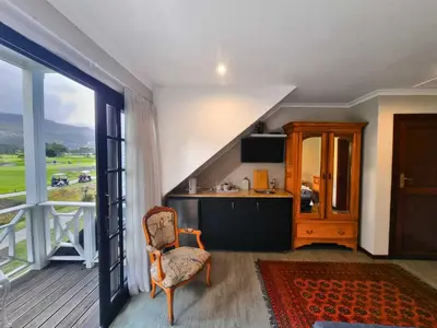 a living room with a kitchen and an open door at Mulligans Guest Lodge in Hermanus