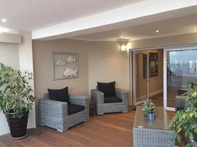 a living room with two chairs and a table at Hermanus Boutique Guest House in Hermanus