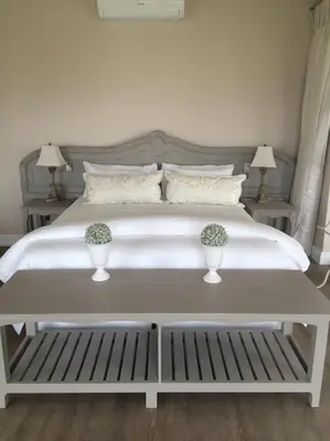 a bedroom with a white bed with two vases on it at Hermanus Boutique Guest House in Hermanus