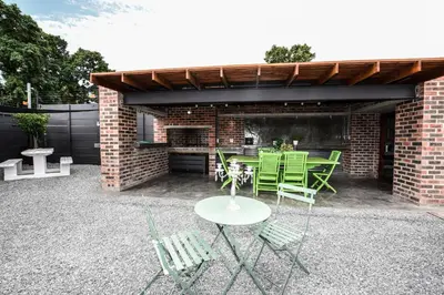 a patio with a table and chairs and a brick building at OnQ Accommodation in Bellville