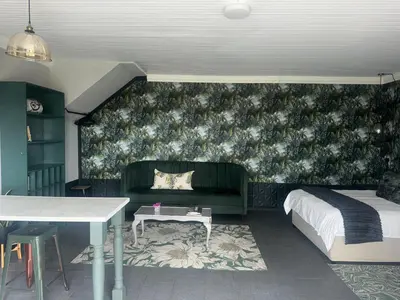 a bedroom with a bed and a couch and a table at Welgemoed Villa in Bellville
