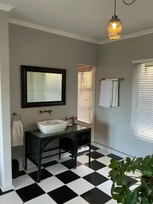 a bathroom with a sink and a checkered floor at Welgemoed Villa in Bellville