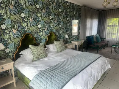 a bedroom with a large bed with floral wallpaper at Welgemoed Villa in Bellville
