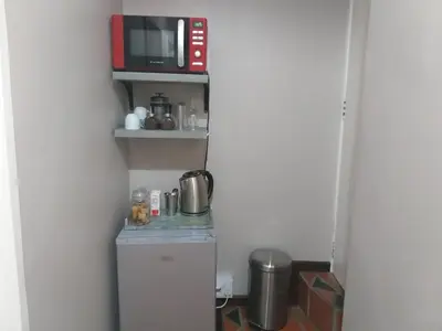 a small kitchen with a microwave and a refrigerator at The Wild Fig in Durbanville