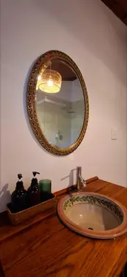 a bathroom sink with a mirror on a wooden counter at The Wild Fig in Durbanville