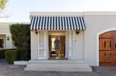 a woman standing in the doorway of a house at Lemoenkloof Boutique Hotel in Paarl