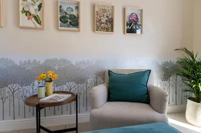a living room with a chair and a table at Lemoenkloof Boutique Hotel in Paarl