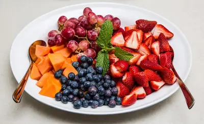 a plate of fruit on a white plate at Penelope's Stellenbosch in Stellenbosch