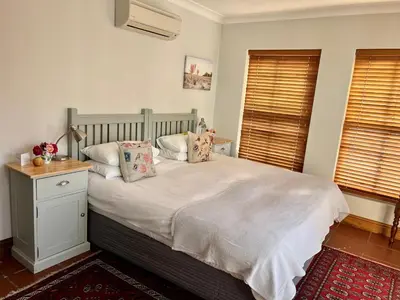 a bedroom with a bed with pillows on it at Penelope's Stellenbosch in Stellenbosch