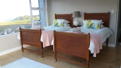 two twin beds in a room with a window at Tranquility Heights in Pringle Bay