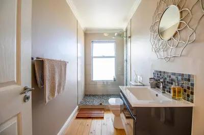 a bathroom with a sink and a toilet and a mirror at Tranquility Heights in Pringle Bay
