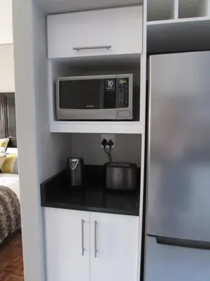 a kitchen with a microwave and a refrigerator at Live Like a Local: Studio 29 @ 25 Market street in Stellenbosch