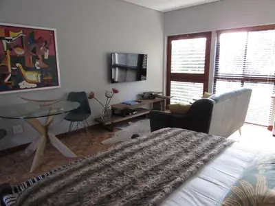 a bedroom with a bed and a desk and a table at Live Like a Local: Studio 29 @ 25 Market street in Stellenbosch