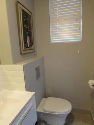 a bathroom with a white toilet and a window at Live Like a Local: Studio 29 @ 25 Market street in Stellenbosch