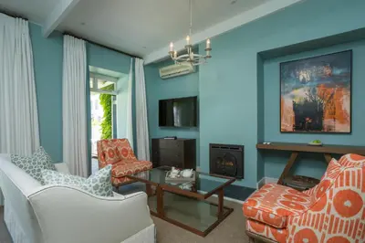 a blue living room with two chairs and a table at Le Quartier Francais in Franschhoek