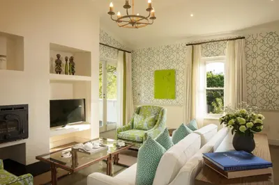 a living room with a white couch and a tv at Le Quartier Francais in Franschhoek
