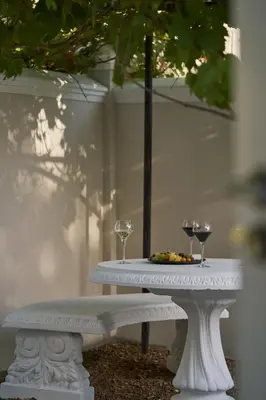 a white table with two glasses of wine on it at Le Quartier Francais in Franschhoek
