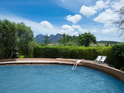a swimming pool with a chair in a yard at Babylonstoren in Simondium