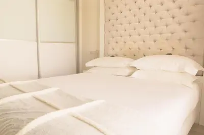 a bedroom with two beds with white sheets and pillows at Homestead Villas in Bellville