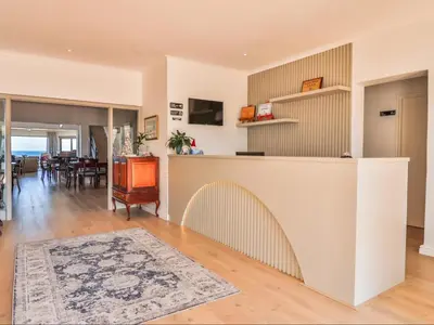 a living room with a counter and a dining room at Sandbaai Country House in Hermanus