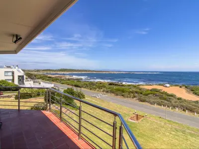 a balcony with a view of the ocean at Sandbaai Country House in Hermanus