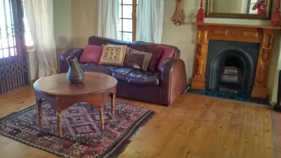 a living room with a leather couch and a table at Getaway on Peck Way in Edgemead