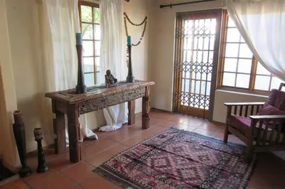 a room with a table and two windows and a rug at Getaway on Peck Way in Edgemead