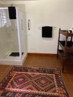 a bathroom with a shower and a rug on the floor at The Prime Spot Self Catering in Worcester