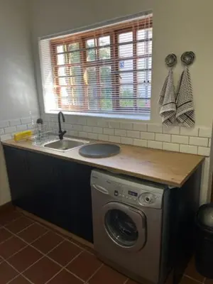 a kitchen with a sink and a washing machine at The Prime Spot Self Catering in Worcester