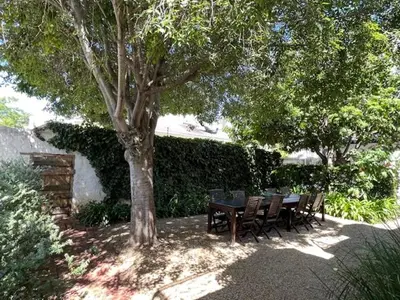 a wooden table and chairs under a tree at The Prime Spot Self Catering in Worcester