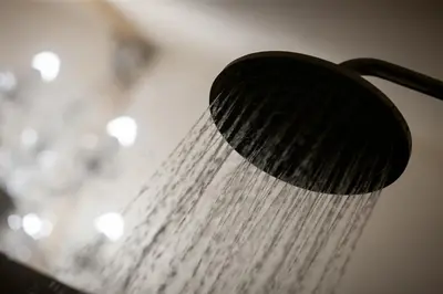 a shower head with water coming out of it at Heuwelsig Farm Cottages in Franschhoek