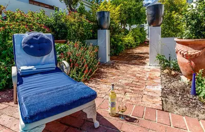 a blue chair sitting on a brick patio at Bleu Cobalt Cottage in Franschhoek
