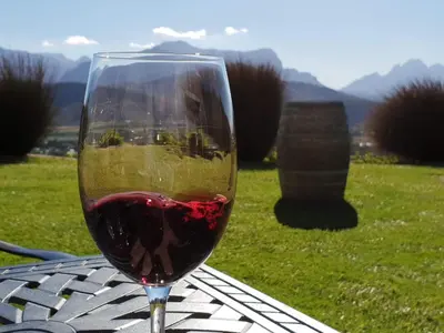 a glass of red wine sitting on a table at Bleu Cobalt Cottage in Franschhoek
