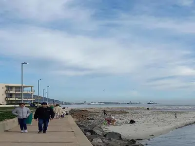 a group of people walking along the beach at Cape Beach Penthouse in Cape Town