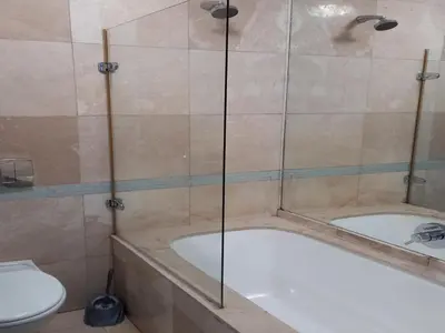 a bathroom with a bath tub and a toilet at Cape Beach Penthouse in Cape Town