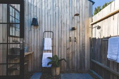 a bathroom with a wooden wall with a sink at The Farmstead in Franschhoek