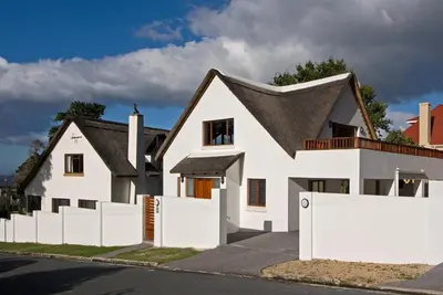 a white house with a white picket fence at Pacem cottage in Hermanus